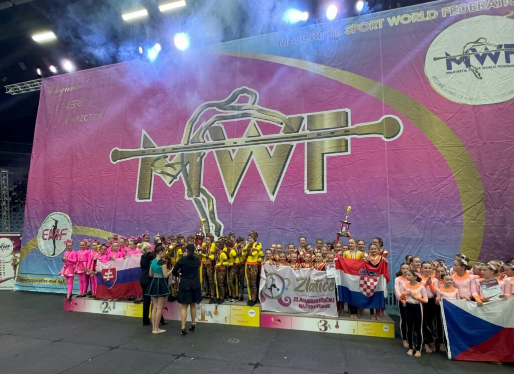 Zlatarbistričke mažoretkinje Zlatice – grupna fotografija kadetkinja na postolju za 3.mjesto na Europskom prvenstvu s MWF natpisom